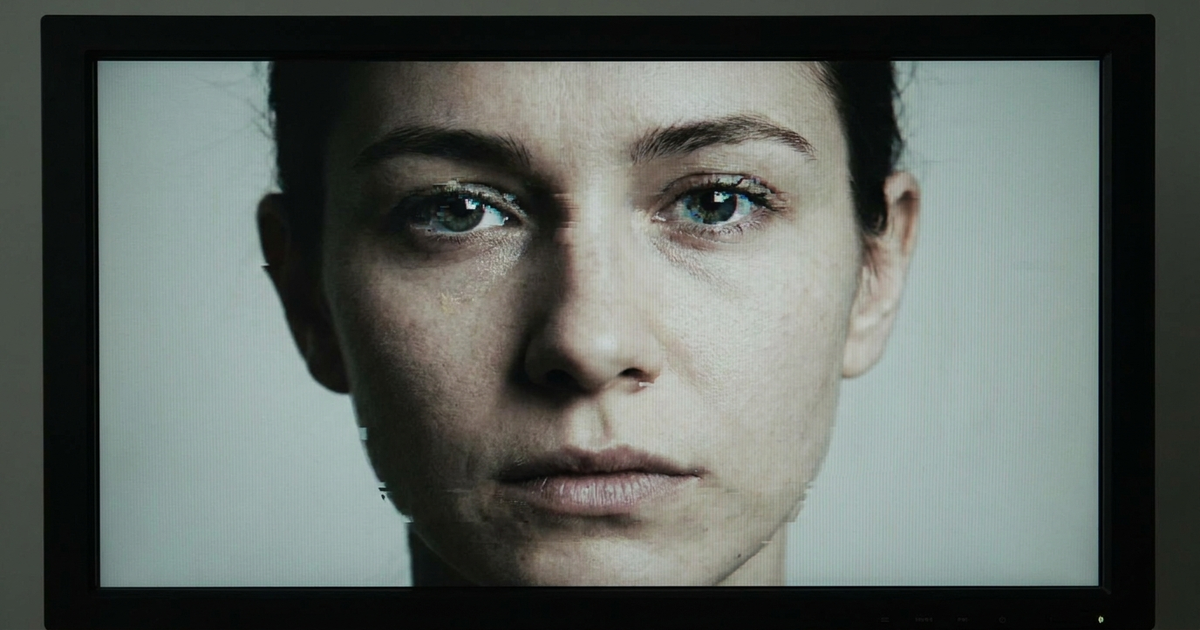 A video frame with a subtle glitch artifact around a face, representing the visual seams left behind by a deepfake video A video frame with a subtle glitch artifact around a face, representing the visual seams left behind by a deepfake video
